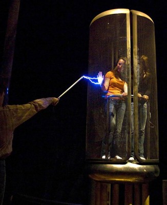 A Faraday cage in operation.  The women inside  the cage are perfectly safe because the cage distributes the charge around the outside of the structure (Image: Antoine Taveneaux/Wikimedia Commons)